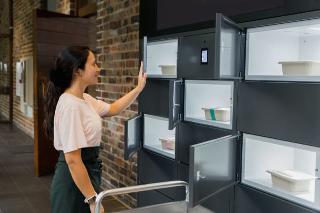 Customer collecting a prepared meal from a modern food pickup locker