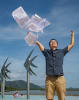 Composer Sam Wu in the famous Cairns Esplanade Lagoon, throwing his sheet music in air celebrating his multiple commissions to be premiered in Cairns this year as part of the Australian Festival of Chamber Music. Photo Brian Cassey.    