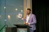 Melbourne AI agency owner Aamir Qutub showcasing his book The CEO who mocked AI during his Keynote session