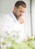 Bernard Blerot, VP R&D Naturals at IFF, smelling geranium in a botanical research laboratory.