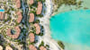 An aerial view of Four Seasons Resort and Residences at Shura Island, set along the shoreline with clear views of the Red Sea.