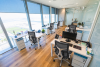 An open-plan Australian office with five desks visible, each fitted with a Sihoo M57 Pro chair