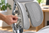 A hand adjusting the lumbar support on a Sihoo Doro S300. Natural light, softly blurred home office background. 