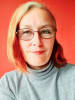 Photo of Freja Leonard smiling warmly against a red background