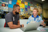 Charles Darwin University (CDU) third year Bachelor of Public Health student Shaheer Muhammad takes Dripstone Middle School Year 9 student Evan Parker through setting up a myGov account.