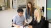 From left: Software engineer Kevin Yi Chen and PhD candidate Lara Alexander, part of the interdisciplinary PainWaive team, speak with Professor Sylvia Gustin.