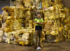 Soft Landing staff member standing in front of a stack of recovered mattress foam, baled and ready to be sent to Australian carpet manufacturers to be recycled into carpet underlay. 