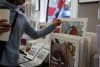 Shopper browsing illustrations of native plants at the Coal Loader Artisans Market.