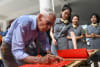 On November 5th, 2023, at the Wuling Campus of Huxi Experimental Middle School in Liuzhou, Moyer (the first from the left), a Flying Tigers veteran, signed and left a message during the visit.