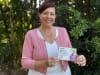 STEPS Pathways Charity Manager Katrina May holds up STEPS Pathways Charity 100 Connect postcard.