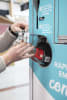 Customer returning a Loop reusable bottle at a Carrefour store in France