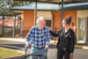 Community health client and staff member walking together outdoors.